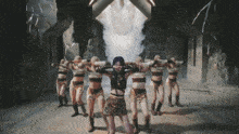 a group of women are dancing in a dark room with smoke coming out of the ceiling