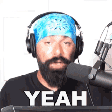 a man wearing headphones and a blue bandana says yeah