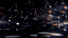 a group of people are playing drums in a dark room .
