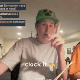 a man wearing a green hat says " clock it " while eating food