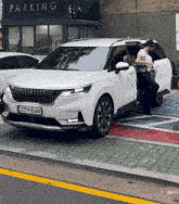 a white car with a license plate that says 377 8644 is parked in a handicapped parking spot