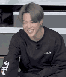 a close up of a person wearing a black sweatshirt and smiling .