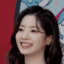 a close up of a woman 's face smiling in front of a cartoon background .