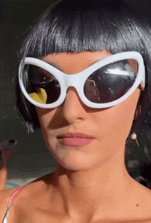 a woman wearing a wig and white sunglasses