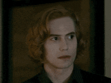 a close up of a man with long red hair