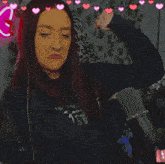 a woman flexing her muscles in front of a microphone with hearts around her