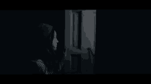 a woman is opening a door in the dark .