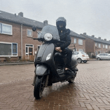 a man wearing a helmet is riding a black scooter