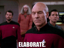 a bald man in a red uniform says elaborate in front of a group of men