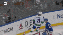 a hockey player with the number 21 on his jersey stands on the ice