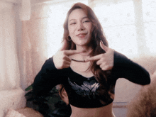 a woman in a black crop top is giving a thumbs up