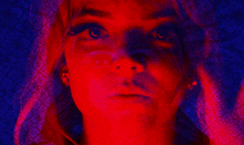 a close up of a woman 's face with red and blue lights