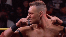 a wrestler is making a funny face with his fingers in his nose