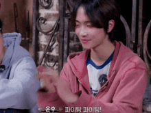 a young man wearing a pink hoodie and a white shirt with the word " wear " on it
