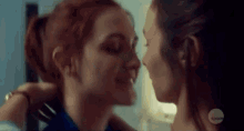 a couple of women are kissing each other on the cheek .