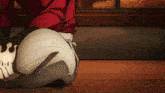 a man in a red shirt and white pants is kneeling on the floor