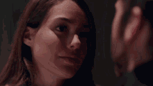 a man and a woman look at each other in a dark room