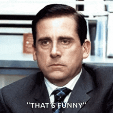 a man in a suit and tie is saying that 's funny .
