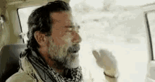 a man with a beard is sitting in a car .