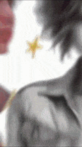 a blurry picture of a person 's back with a yellow star in the background