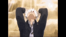 a man with white hair is standing with his hands behind his head .