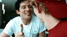 two men are looking at each other and one is holding a stick