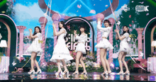 a group of girls are dancing on a stage in front of a studio k sign