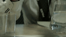 a man sitting at a table with a bbc logo on the bottom right