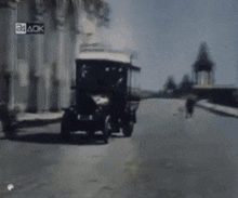 a car is driving down a street with a sign that says 24 ack