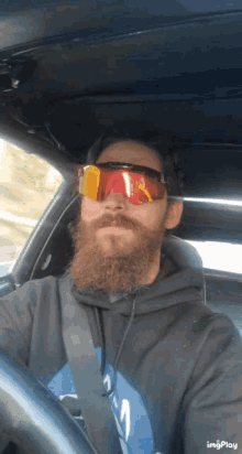 a man with a beard wearing sunglasses and a black hoodie