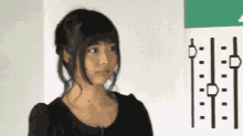 a woman in a black dress stands in front of a white board with a drawing of a clock on it