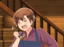 a man in overalls is talking on a phone with his mouth open