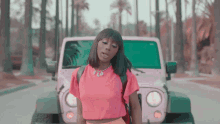 a woman wearing a pink shirt with flo on it