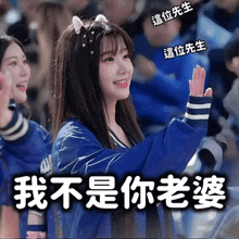 a girl in a blue jacket with a cat ear headband is giving a high five in a crowd .