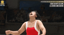 a female wrestler in a red and white outfit stands in front of a banner that says ' hawaii ' on it