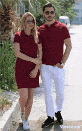 a man and a woman are standing next to each other wearing matching red shirts and white pants