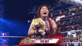 a woman in a wrestling ring is holding a belt that says new women 's world champion iyo sky
