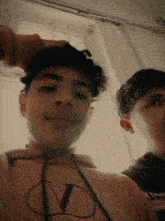 two young men are standing next to each other and one of them is wearing a hoodie with the letter v on it