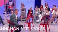 a group of people are sitting in red chairs with the words anni non siete sposati written on the bottom