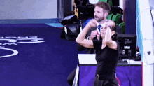 a woman in a black shirt is flexing her muscles in front of a man in a suit