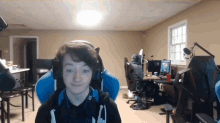 a young boy wearing headphones is sitting in a blue chair in a room .