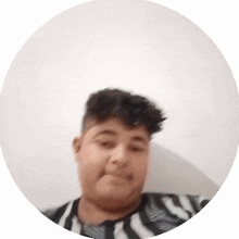 a young man in a zebra print shirt is making a funny face in a circle .