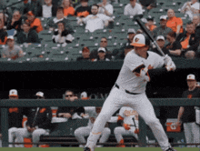a baseball player getting ready to swing at a ball in front of a crowd