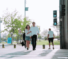 a couple walking across a street with the word favorite on the bottom right