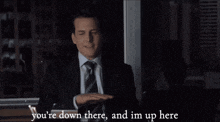 a man in a suit and tie is saying " you 're down there and im up here "