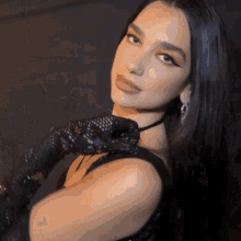 a woman with long black hair is wearing a choker and gloves .