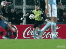 a soccer game is being played in front of an advertisement for coca-cola