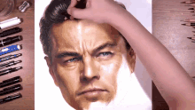 a person is drawing a man 's face with a marker that says ' marte ' on it