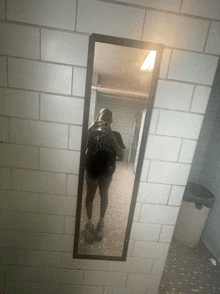 a woman is taking a picture of herself in a mirror with a shirt that says " i am a girl "