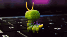 a green and yellow caterpillar is sitting on a keyboard with the letters h and n on it